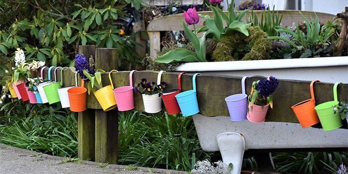 colorful planter containers hanging on a fence