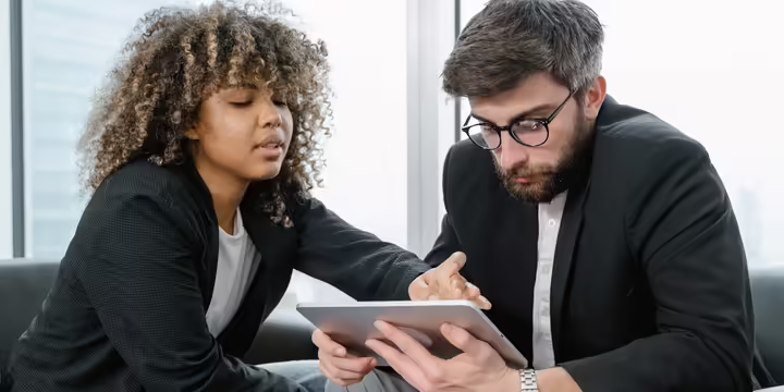two people consulting a tablet