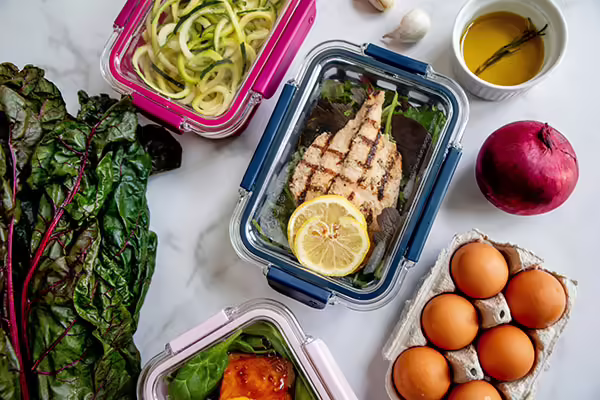 kale, zucchini noodles, chicken, eggs, onion, garlic being used as balanced meal prep items