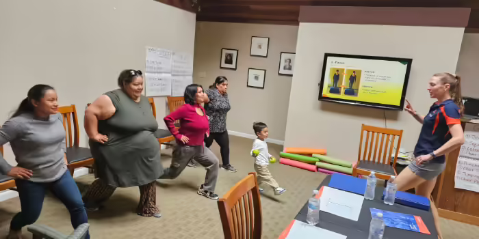 educator demonstrating proper stretching techniques to a class
