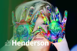 boy with paint covered hands. text henderson