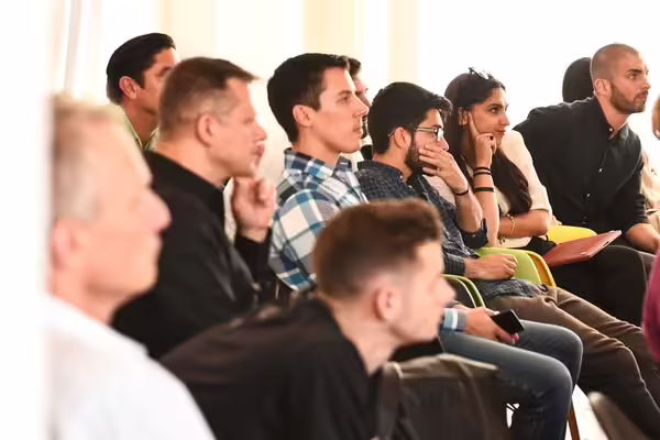 diverse group of people listening intently to presentation speaker