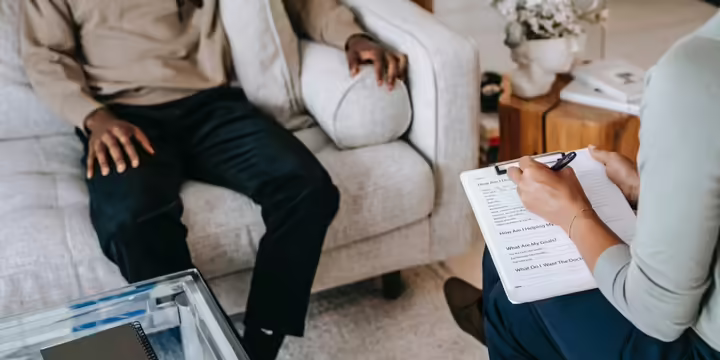 person sitting in chair another person writing things down