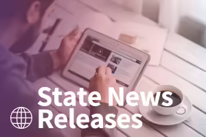 white male looking at news on an ipad at a table. test state news releases