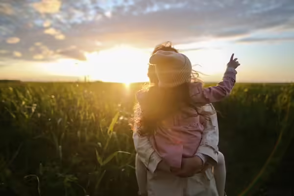 parent giving horseback ride child walking into sunset
