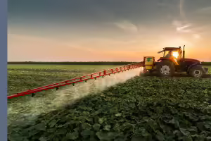 Tractor applying pesticide in field