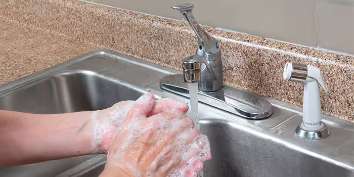 person washing hands with soap and water