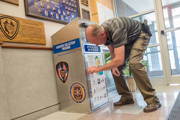 Officer empties the old medicine take-back box