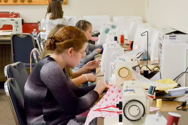 4-H girls sewing cloth bags for children battling cancer