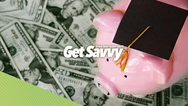 Piggy bank wearing academic mortarboard, standing on scattered U.S currency