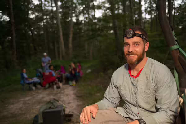 man watching for bats in the woods