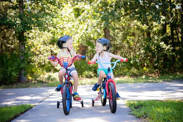 two children riding bikes with helmets on their heads