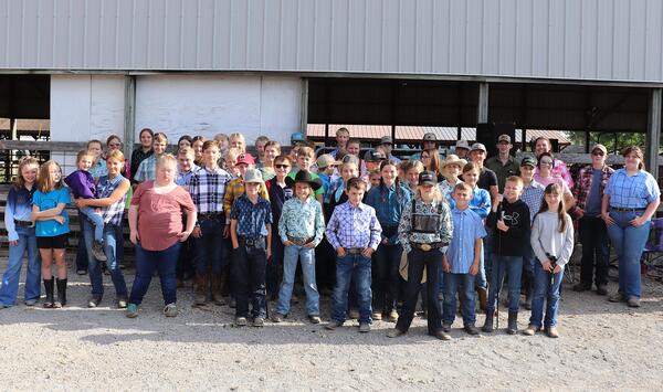A group of 4-H youth near a show barn.