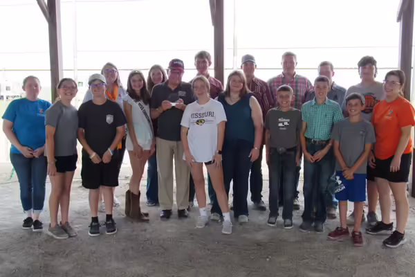 Randy Miller is in the middle, proudly holding the award while surrounded by Christian County 4-H members and Christian County Extension staff.