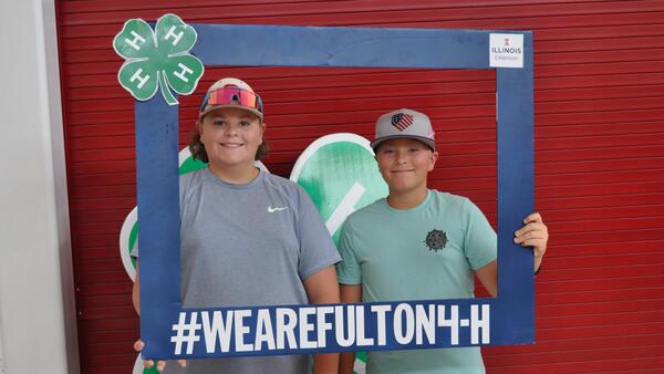 two 4-H boys holding a big frame