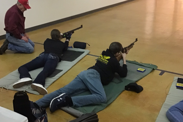 Youth lay on the ground and aim rifles
