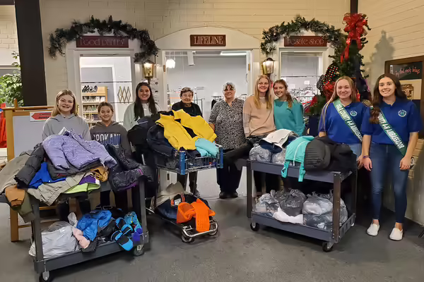 group of youth with adults standing in front of winter gear
