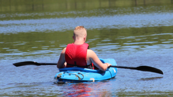 Boy rides in a kayak.