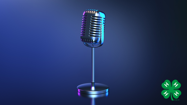A microphone on a dark navy blue background with a green 4-H clover in the bottom right corner.