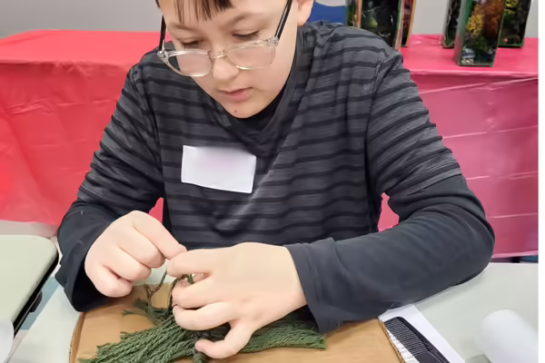 boy doing a macrame craft project