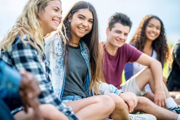 group of teens sitting on the ground