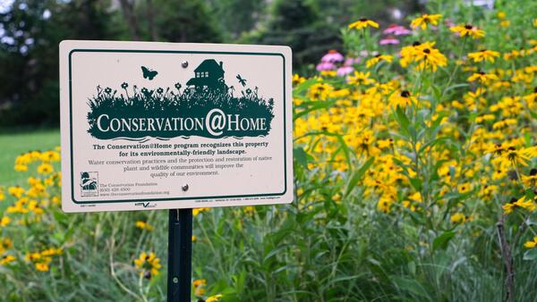 Conservation@Home sign in a flower bed