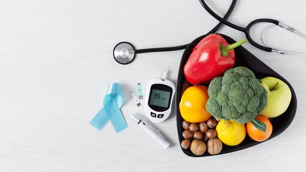 Diabetes awareness ribbon , blood monitor kit, vegetables, and stethoscope