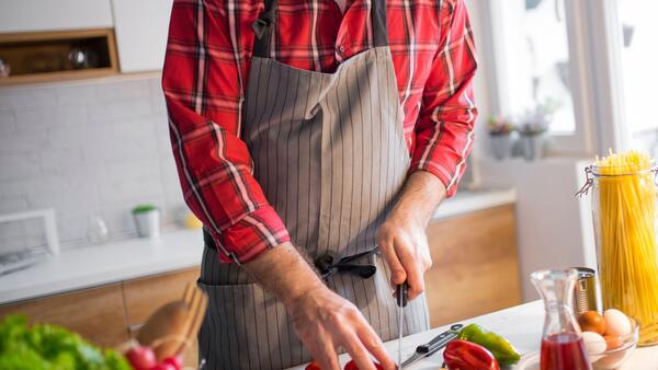 Cooking for One or Two, person in an apron cutting vegetables 