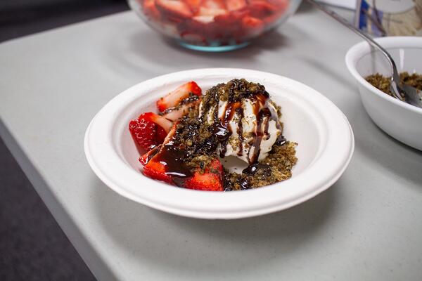 Vanilla ice cream sundae topped with strawberries, chocolate syrup, and crushed cicadas.