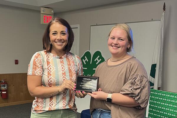 woman presenting an award to a 4-H member