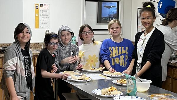 Children posing in a kitchen during a workshop