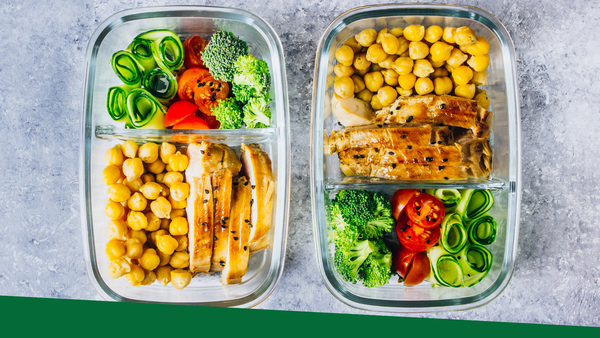 Healthy prep meal containers with chickpeas, chicken, tomatoes, cucumbers, and broccoli.