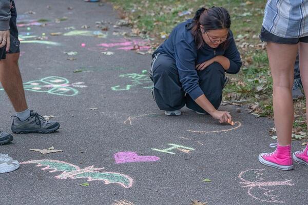 a woman draws a bat with chalk