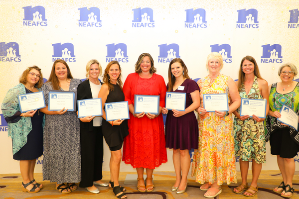 Image of a group of women holding awards and smiling at the camera.