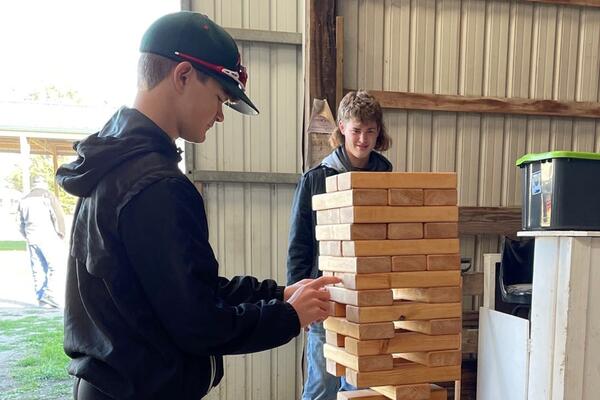 Two youth playing giant Jenga