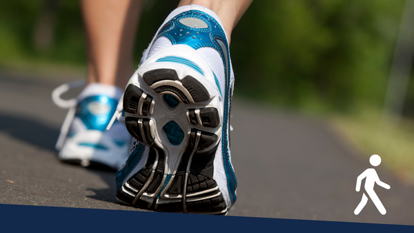 Tennis shoes of a person walking on a paved path.