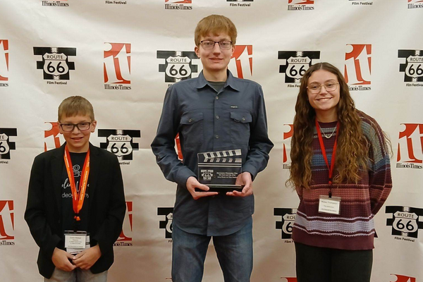 Youth participants pose at a step and repeat.