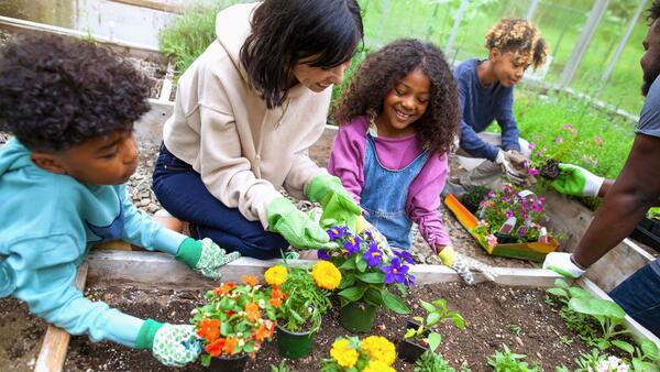 Woman teaching kids how to plant marigolds