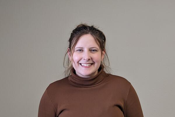 headshot of woman wearing a brown turtleneck shirt