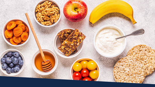 Healthy snacks laid out on a white marble background.