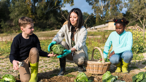 Adult with two kids gardening