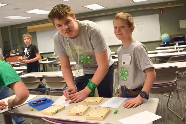 two boys working over a table