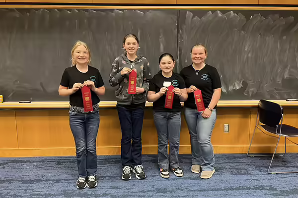 Four youth standing with red ribbons