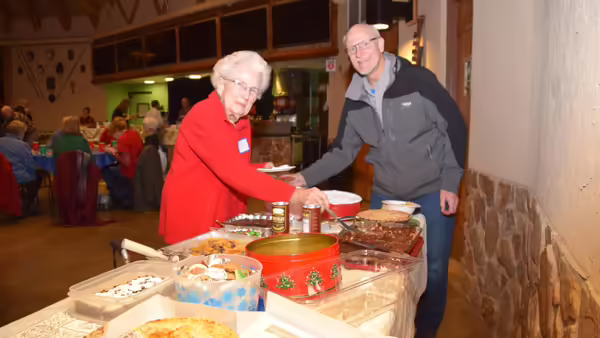 a man and a woman going through a buffet line