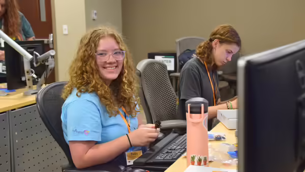 a girl sitting at a computer