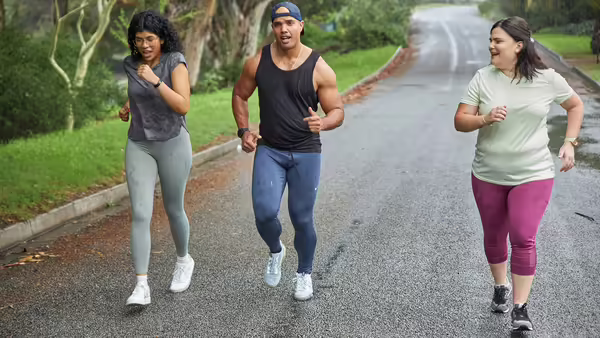 Three adults walking on road