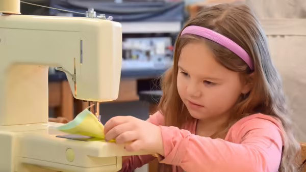 a little girl sewing