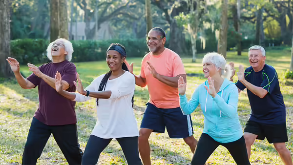 people in a park practicing tai chi movements