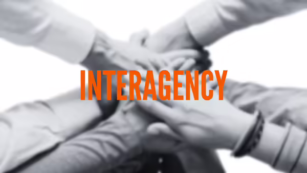 hands piled together with the word Interagency
