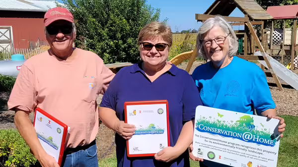 a group of people holding a Conservation@Home sign